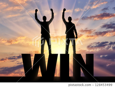 Silhouette of two happy men with raised arms standing on the word win. 128453499