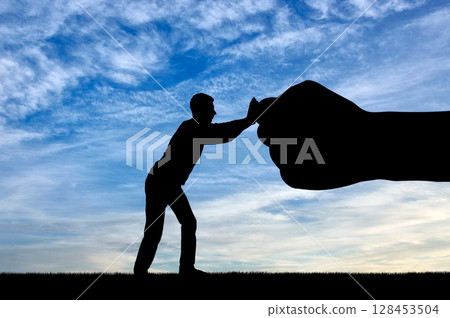 Silhouette of man resists big fist hand 128453504