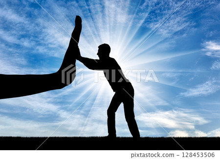 Silhouette of a man resists a big hand that wants to stop him. Silhouette of a man resists a big hand that wants to stop him. 128453506
