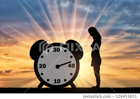 Sad woman standing at the clock hand which shows almost 40 years 128453653