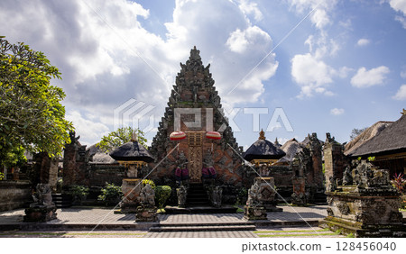 Monkey sculpture fully covered with green moss in Ubud's Monkey Forest. Bali, Indonesia. 128456040