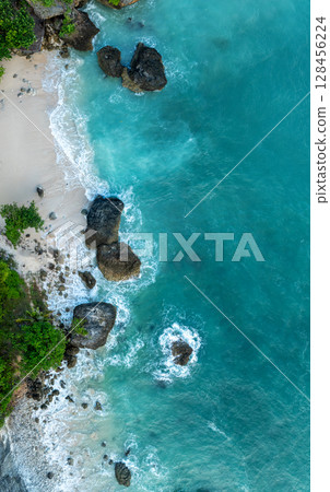 Top Aerial view of impossible Beach in Bali, Indonesia. Empty paradise beach, blue sea waves in Bali island, Indonesia 128456224
