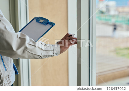 一個穿著工作服的年輕人在檢查某件東西 128457012