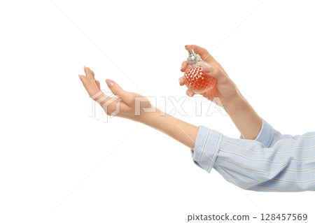Elegant glass bottle dispenses fragrance, on white background Elegant glass bottle dispenses fragrance, on white background 128457569