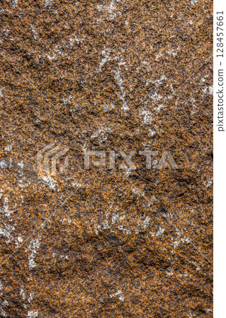 Rough textured brown and black granite rock with white inclusions - texture and background Rough textured brown and black granite rock with white inclusions - texture and background 128457661