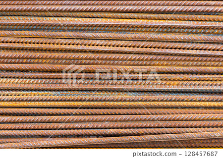 Rusty metal rebar rods arranged in parallel at construction site 128457687