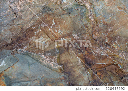 Rugged rock formation in natural outdoor setting during daytime, full-frame closeup 128457692