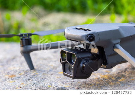 Drone on flat concrete surface with green grass in the background Drone on flat concrete surface with green grass in the background 128457723