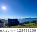 Mountain landscape with houses under a clear blue sky. 128458109