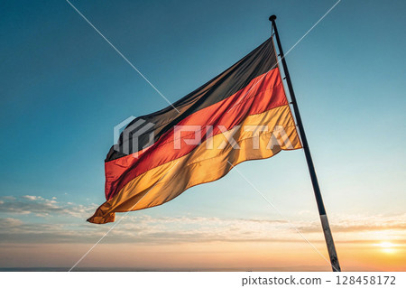 German flag waving at sunset with colorful sky. 128458172