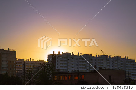 Sunset behind residential multi-storey buildings Sunset behind residential multi-storey buildings 128458319