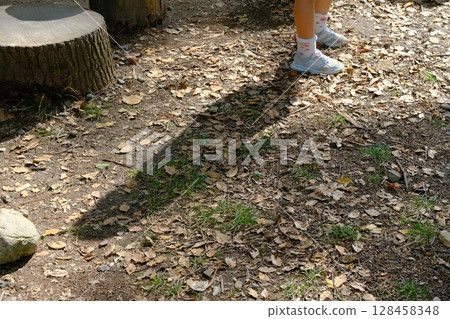 Shadow of a child playing with a stump in the park 128458348