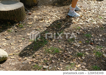 公園裡玩樹樁的孩子的影子 128458349