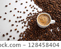 White cup of black coffee with foam surrounded by roasted beans on white surface. 128458404