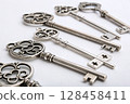 Antique decorative keys in row on neutral background. 128458411