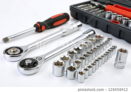 Socket wrench set with ratchets and accessories on white background. 128458412