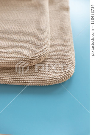 Textured woven mats displayed on a vibrant blue surface in a well-lit setting 128458734