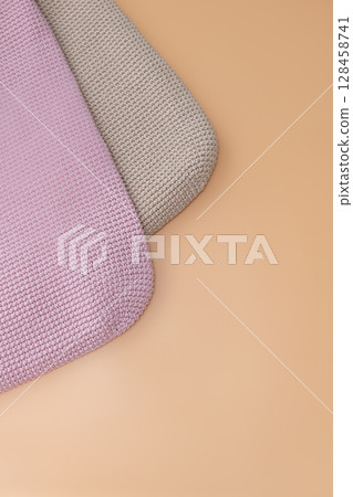 Crocheted cushions in soft pastel colors arranged on a beige surface Crocheted cushions in soft pastel colors arranged on a beige surface 128458741