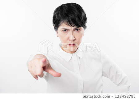 Angry middle-aged woman pointing at something Angry middle-aged woman pointing at something 128458795