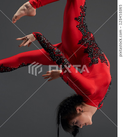 Young slim gymnast with red hoop studio portrait 128458865