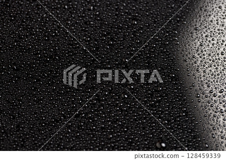 black and white glass surface in water drops closeup, wet mirrored black glass in a large number of water droplets 128459339