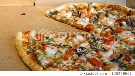 Several images showing a delicious shrimp pizza with tomatoes, mushrooms and pesto being sliced and a slice being taken from the cardboard box Several images showing a delicious shrimp pizza with tomatoes, mushrooms and pesto being sliced and a slice being taken from the cardboard box 128459661