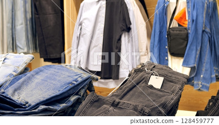 Black jeans hanging on display with blank price tags, representing modern fashion trends and showcasing versatile wardrobe staple for stylish shoppers in retail environment. Concept fashion clothes Black jeans hanging on display with blank price tags, representing modern fashion trends and showcasing versatile wardrobe staple for stylish shoppers in retail environment. Concept fashion clothes 128459777