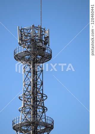 Radio tower towering in the blue sky 128460441