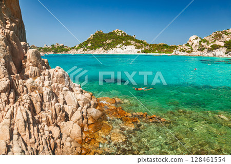 Snorkeler swimming in clear turquoise waters of Cala Corsara bay on Spargi island, Sardinia Snorkeler swimming in clear turquoise waters of Cala Corsara bay on Spargi island, Sardinia 128461554