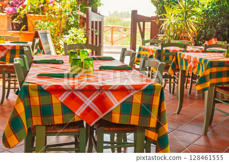 Traditional Mediterranean outdoor dining area with vibrant table decor 128461555