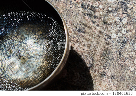 Meditative Sound Bowl. A sound bowl with water reflecting Meditative Sound Bowl. A sound bowl with water reflecting 128461633