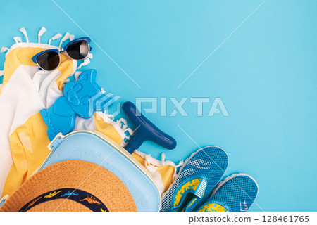 Children's beach essentials including a hat, sunglasses, water shoes, suitcase, and towel. 128461765