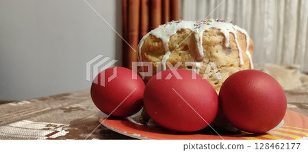 Traditional Easter cake with sprinkles and icing. Red eggs with Easter cake. 128462177