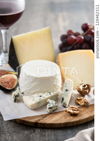 Board of different cheeses with nuts, figs and grapes Board of different cheeses with nuts, figs and grapes 128462311