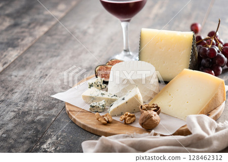 Board of different cheeses with nuts, figs and grapes 128462312