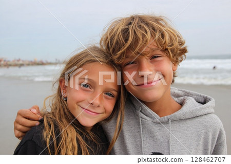 沙灘上兄妹倆互相擁抱的微笑肖像 128462707