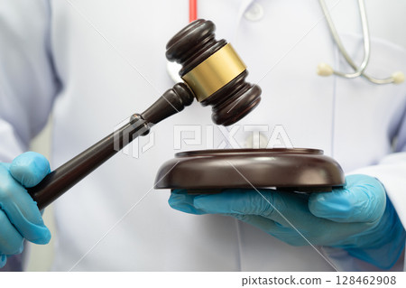 Asian doctor holding court hammer for and crime law justice, forensic medicine. 128462908