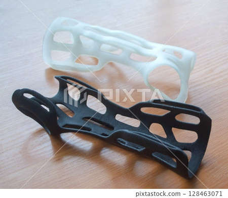 Plastic corset prosthesis. Hand arm splint corset prosthesis langet printed on a 3D printer from molten plastic. Medical orthosis, fixator, plastic overlay created on 3D printer. Printing technologies 128463071