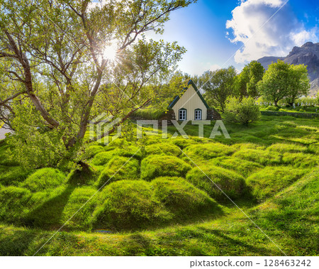 Impressive view of turf-top church Hofskirkja during sunset. 128463242