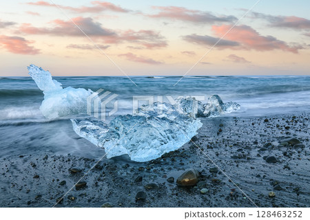 Excellent pieces of iceberg sparkle on famous Diamond Beach at  Jokulsarlon lagoon during sunset. 128463252