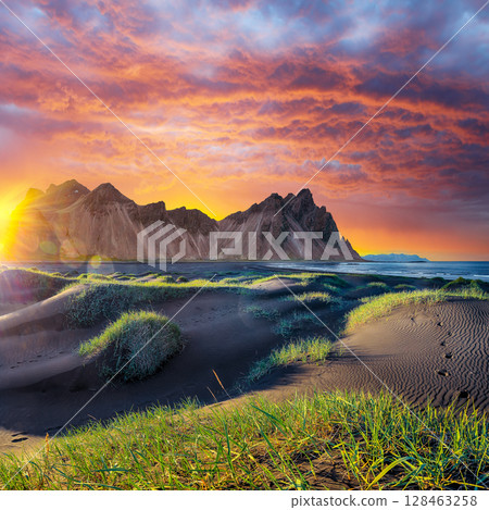 Remarkable sunset with gorgeous black sand dunes on Stokksnes cape in Iceland. 128463258