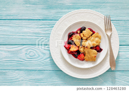 apple blueberry strawberry crumble on white plate 128463280