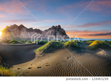 Impressive sunset with gorgeous black sand dunes on Stokksnes cape in Iceland. 128463299