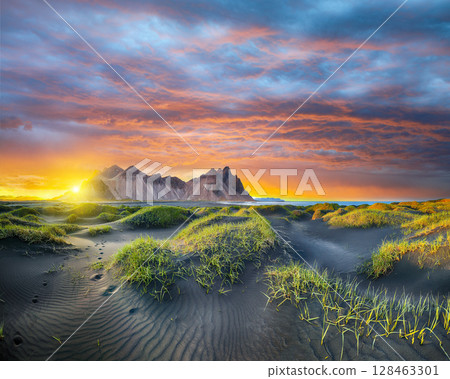 Impressive sunset with gorgeous black sand dunes on Stokksnes cape in Iceland. 128463301