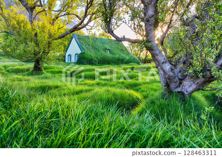 Impressive view of turf-top church Hofskirkja during sunset. 128463311