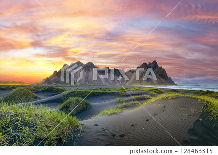 Impressive sunset with gorgeous black sand dunes on Stokksnes cape in Iceland. 128463315