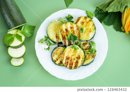 Grilled zucchini slices on a bright green background 128463432