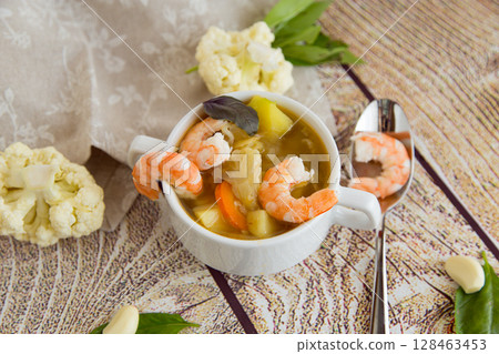 Culinary Serving of Hot Shrimp Soup on a Wooden Table Culinary Serving of Hot Shrimp Soup on a Wooden Table 128463453