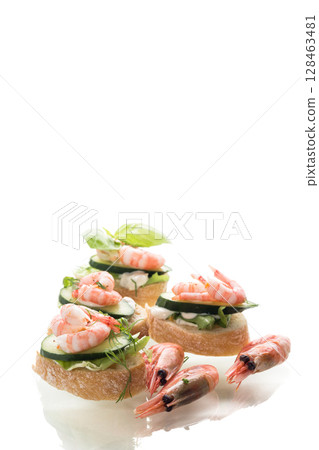 Portioned appetizers with shrimps, salad leaves and sauce isolated 128463481