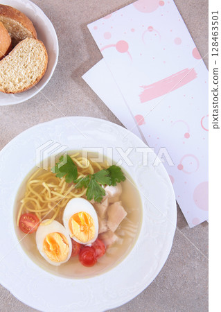 Chicken noodle soup. Chicken broth with egg. Dietary dish. Flat lay. Top view. 128463501